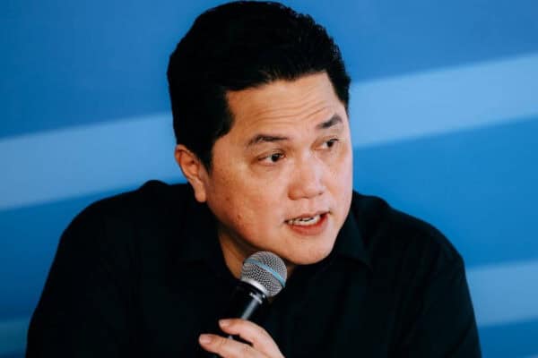 Menteri Erick speaking into a microphone during a formal event.