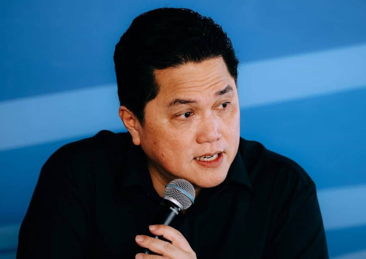 Menteri Erick speaking into a microphone during a formal event.